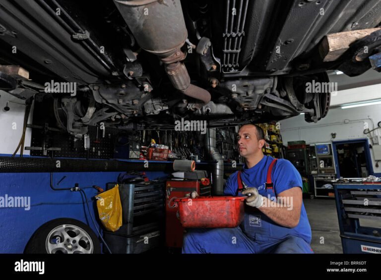 auto in officina con meccanico al lavoro