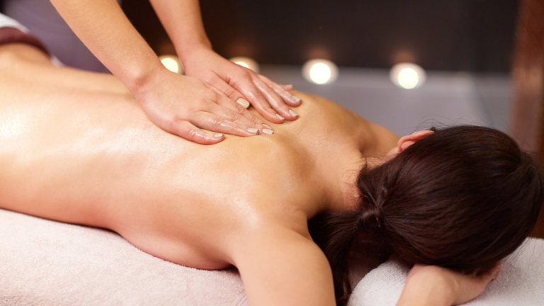 Quali sono i benefici del massaggio olistico a Parma 44 mani che massaggiano dolcemente una schiena