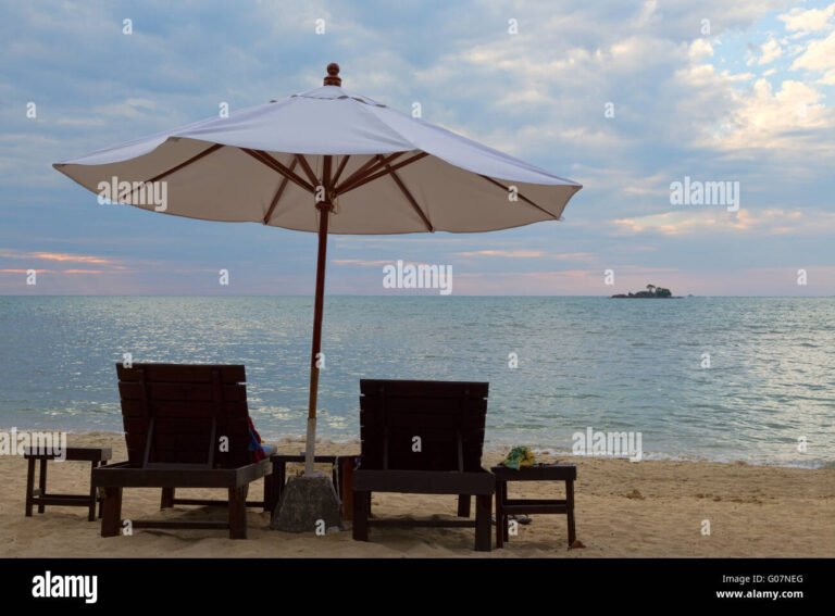 spiaggia al tramonto con lettini e ombrelloni
